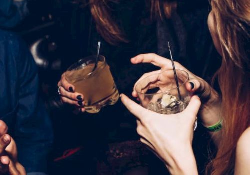 People are enjoying drinks and laughing in a social setting.