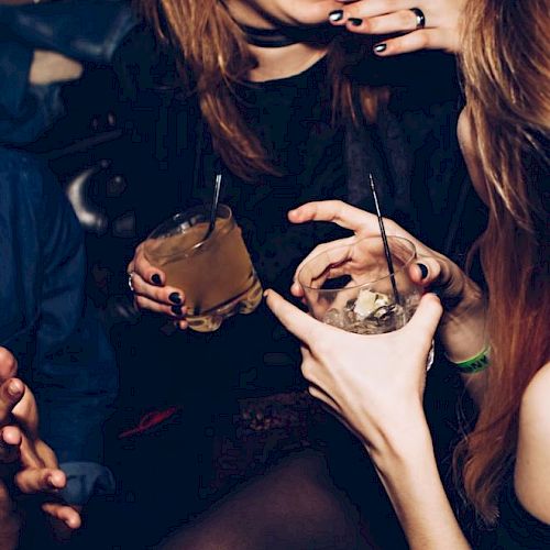 People are enjoying drinks and laughing in a social setting.