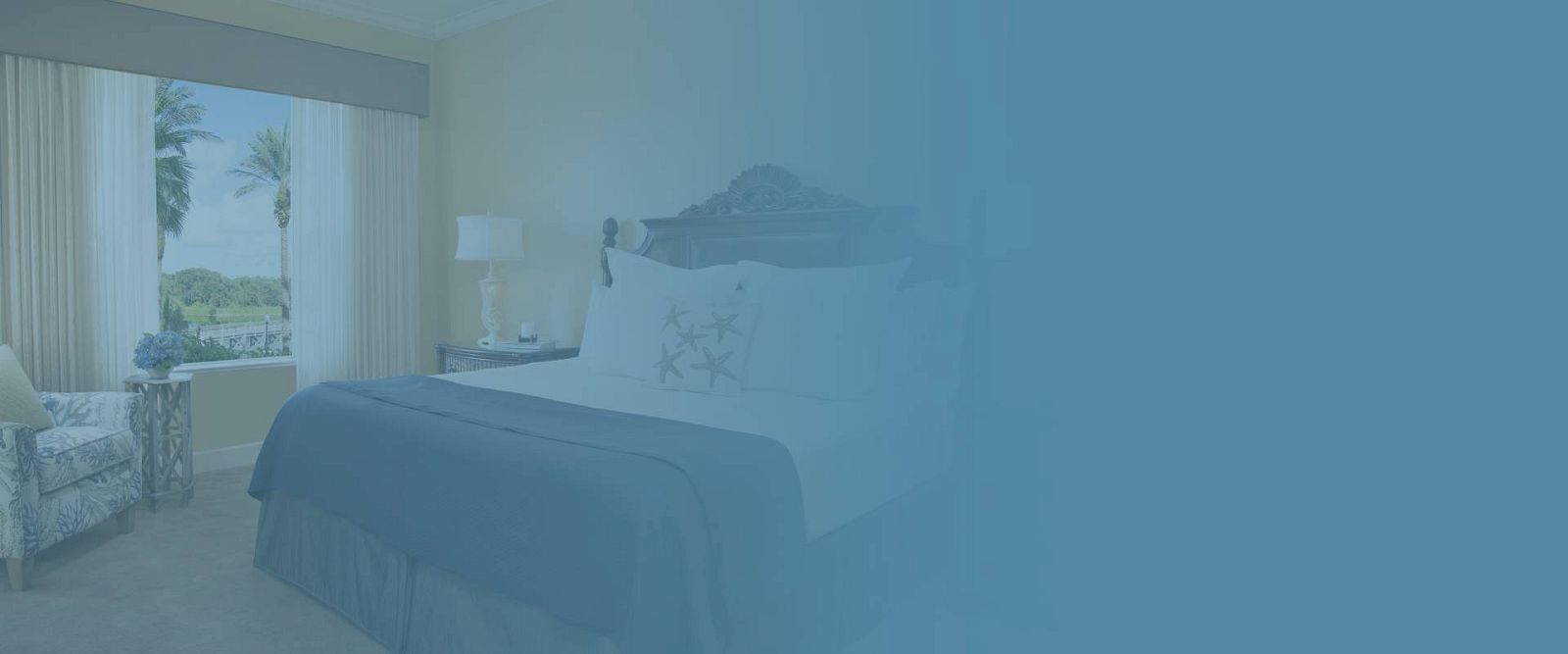 The image shows a cozy bedroom with a bed, a chair, and a window with a nature view, overlaid with a blue tint.