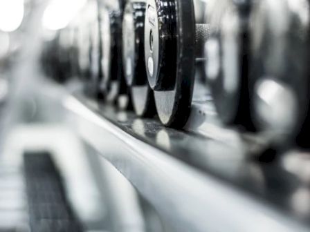 A row of vinyl records on a turntable, spinning on a sleek, silver player with a blurred background.