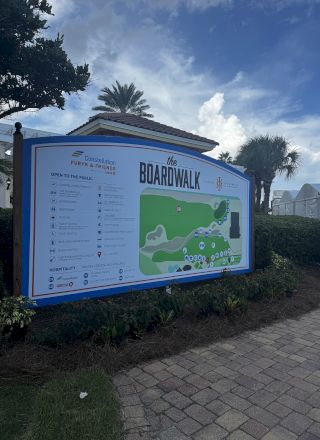 A colorful &ldquo;Boardwalk&rdquo; event map sign with &ldquo;FuryK & Friends/Constellation&rdquo; branding, listing amenities and locations under palm trees.
