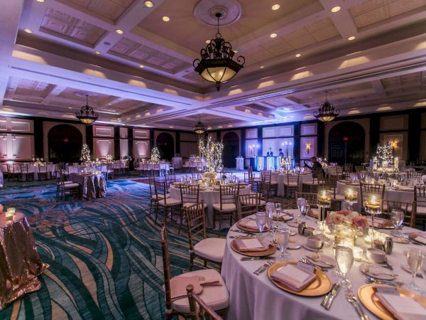A beautifully decorated banquet hall with elegantly set tables, ambient lighting, and upscale decor, ready for a formal event or reception.