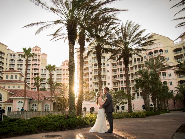 A couple embraces, surrounded by palm trees, with a sunlit resort building in the background.