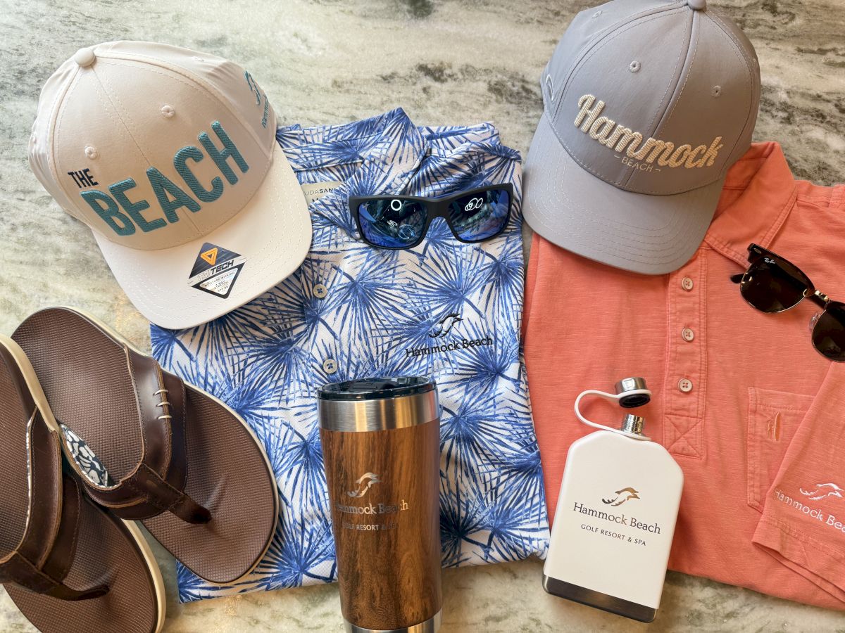 Beach-themed items: two caps, sandals, sunglasses, blue patterned shirt, coral shirt, tumbler, and a bottle.
