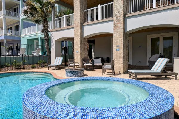 A luxurious backyard features a pool, a hot tub with blue tiles, lounge chairs, and a modern house in the background.